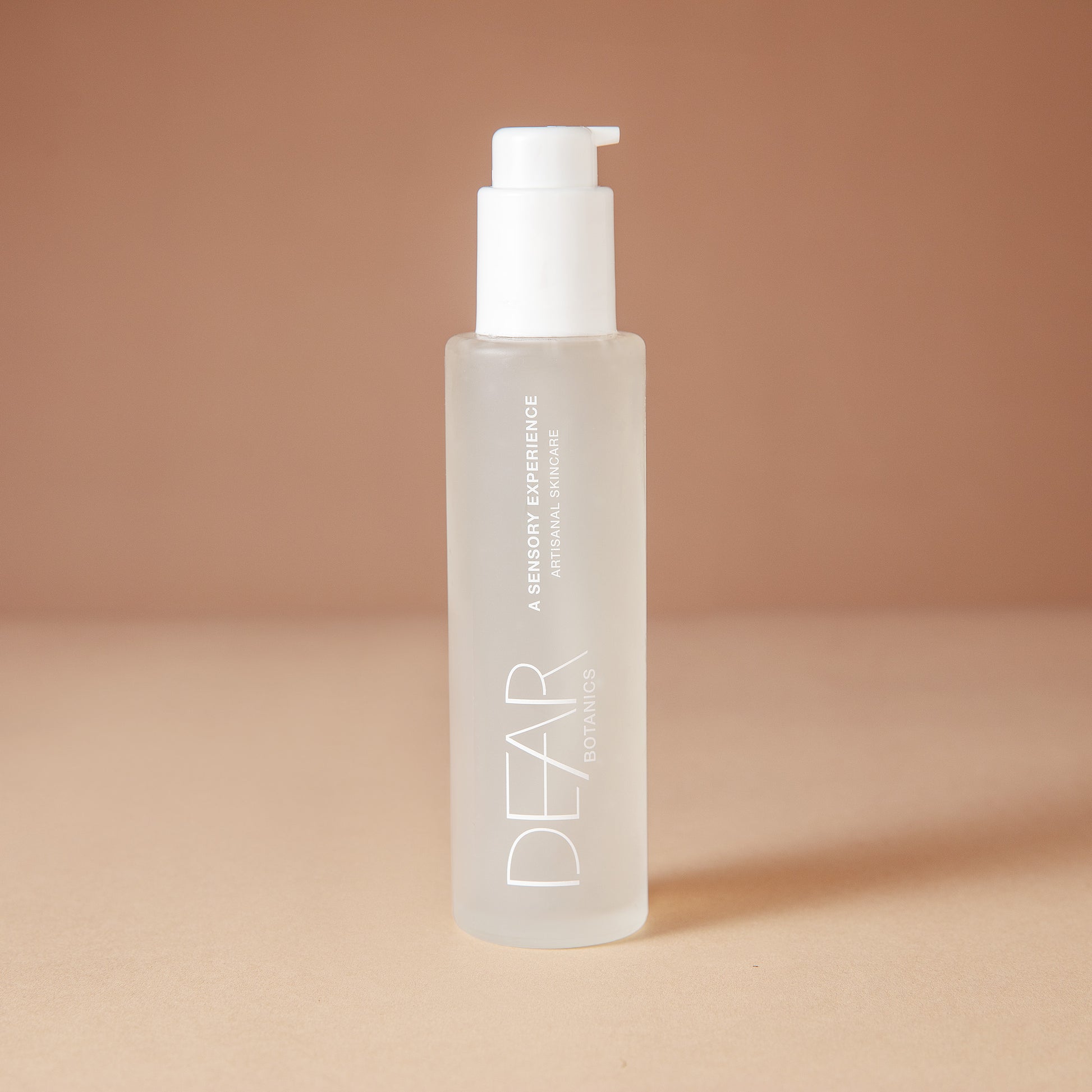 DEAR BOTANICS Face Wash in a 4 ounce frosted glass bottle with a white pump dispenser, set against a warm beige background.